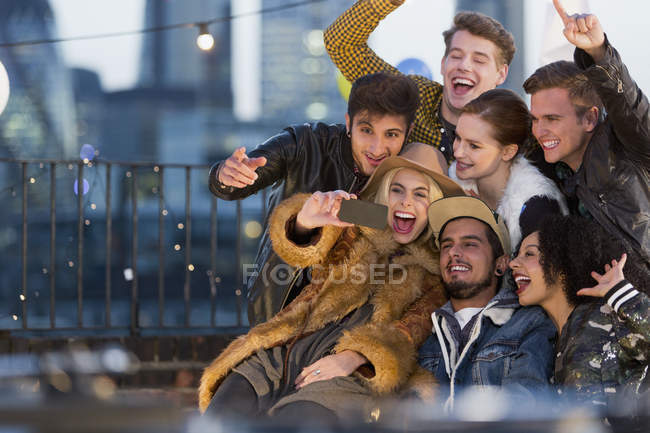 Enthousiaste jeunes amis adultes prenant selfie à la fête sur le toit — Photo de stock
