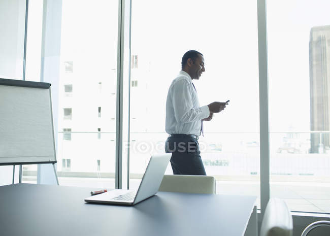 Бизнесмен, использующий мобильный телефон в офисе — стоковое фото