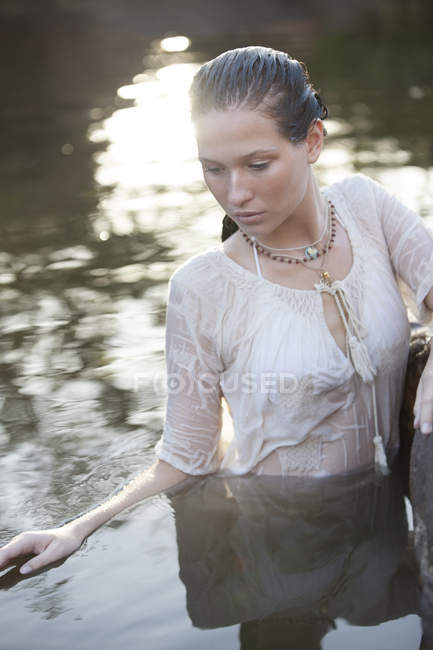Donna serena in piedi nel fiume — Foto stock