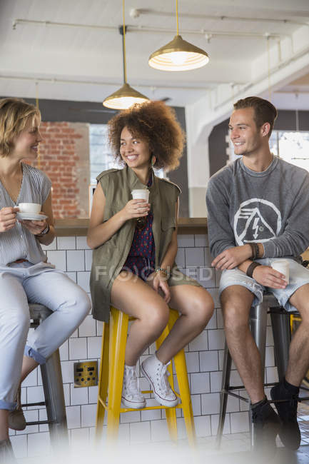 Friends hanging out talking and drinking coffee in cafe — Stock Photo