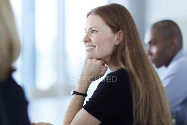 Mujer de negocios segura escuchando en la reunión - foto de stock