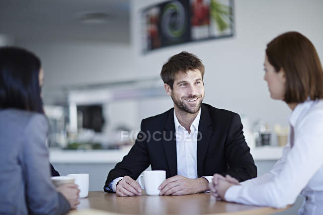 Успішні дорослі бізнесмени розмовляють в кафе — стокове фото