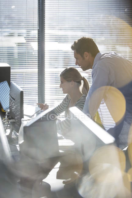 Empresários trabalhando no computador ao lado da janela — Fotografia de Stock