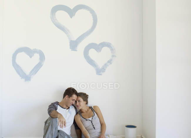 Paar malt blaue Herzen an Wand — Stockfoto