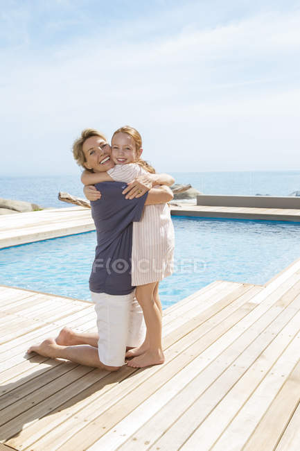 Бабуся обіймає онуку біля басейну — стокове фото