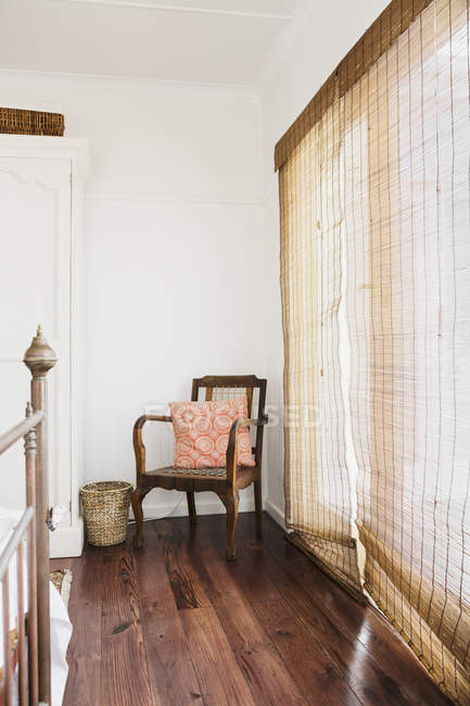 Камышовые шторы и кресло в спальне — стоковое фото