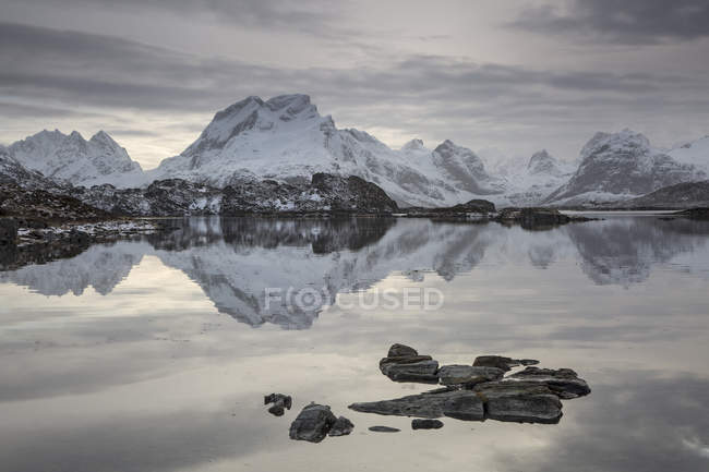 Reflection of snow covered mountain range in calm lake, Norway — Stock Photo