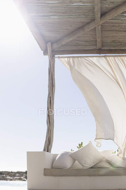 Vento che soffia tenda sul patio soleggiato — Foto stock