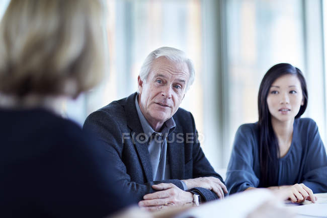 Senior-Geschäftsmann hört bei Treffen zu — Stockfoto