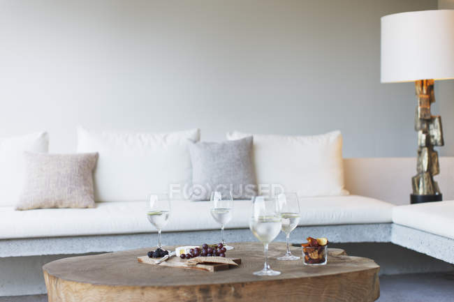 Wein und Käse auf Couchtisch im modernen Wohnzimmer — Stockfoto