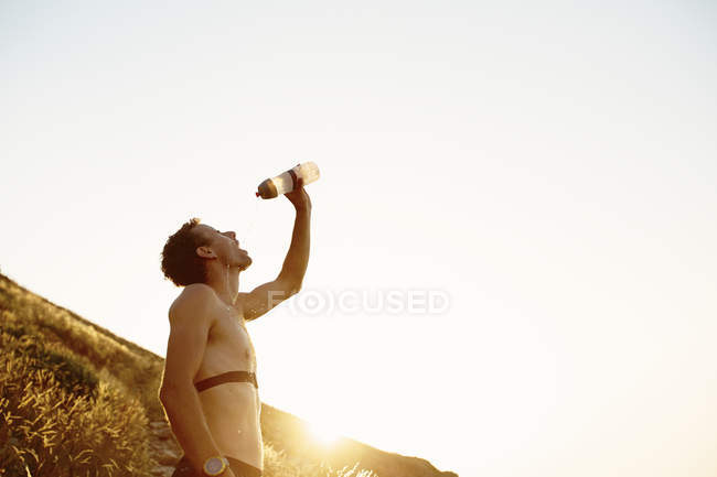 Втомлений бігун чоловічої статі поливає воду на обличчя — стокове фото