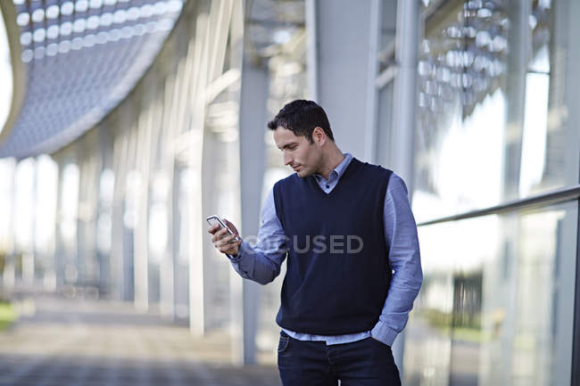 Успешный взрослый бизнесмен, используя мобильный телефон на открытом воздухе — стоковое фото