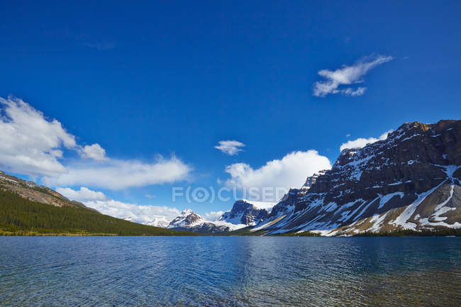 Снежные горы с видом на ледниковое озеро — стоковое фото