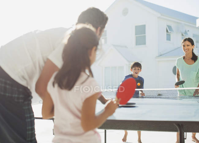 Familie spielt Tischtennis vor Haus — Stockfoto