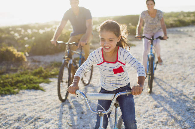 Family riding bicycles on sunny beach — Stock Photo