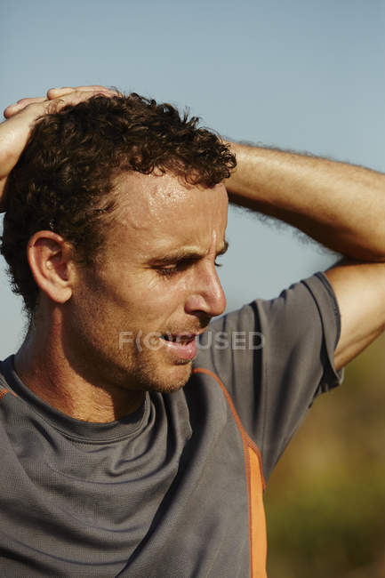 Close up male runner with hands behind head — Stock Photo