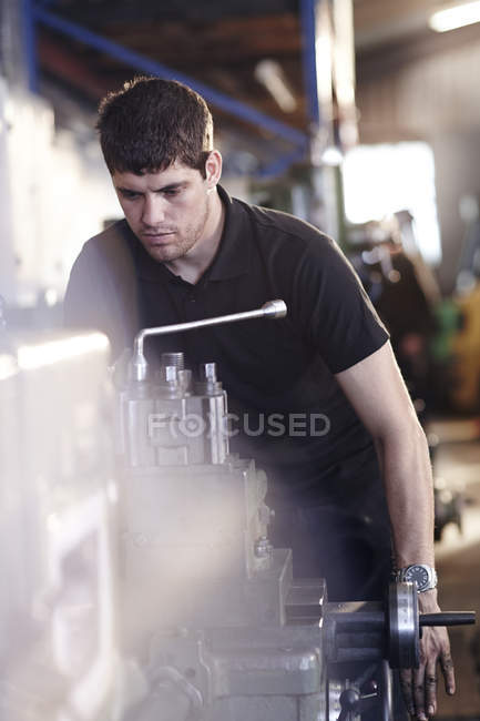 Mecânico de trabalho em máquinas na oficina de reparação de automóveis — Fotografia de Stock