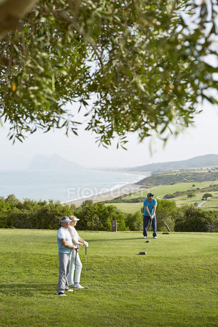 Amigos mayores jugando al golf en el campo - foto de stock
