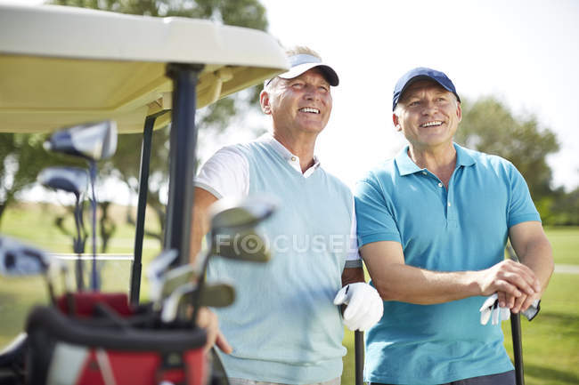 Senior steht neben Golfwagen — Stockfoto