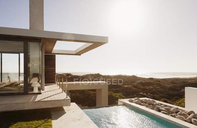 Modern house and swimming pool overlooking ocean — Stock Photo