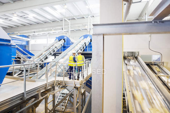 Workers talking on platform in recycling center — Stock Photo
