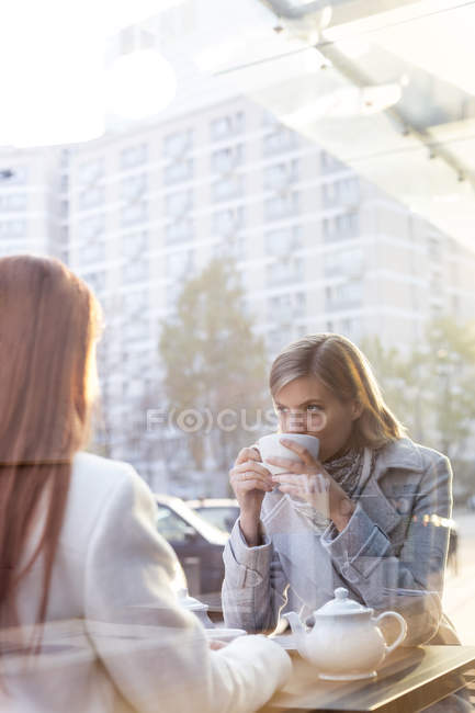 Women drinking tea at sidewalk cafe — Stock Photo