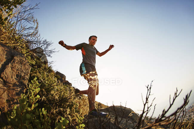 Male runner jumping and descending trail — Stock Photo