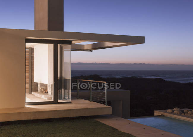 Hermosa casa moderna iluminada al atardecer - foto de stock