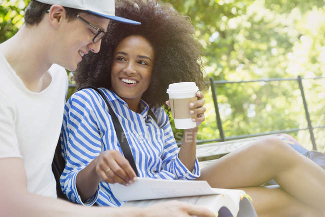 College students drinking coffee and studying in park — Stock Photo