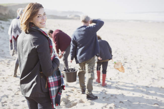 Portrait smiling woman walking on sunny beach with family — Stock Photo