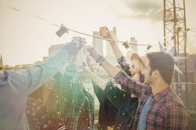 Jovens adultos entusiasmados brindando coquetéis na festa no telhado — Fotografia de Stock