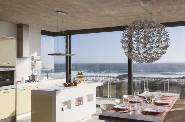 Кухня і їдальня в сучасному будинку з видом на океан — стокове фото