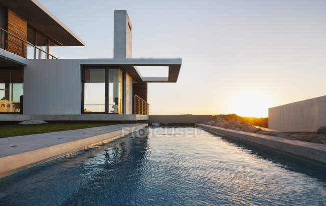 Pool vor modernem Haus bei Sonnenuntergang — Stockfoto