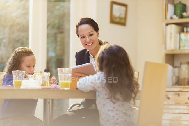 Berufstätige Mutter und Töchter am Frühstückstisch — Stockfoto