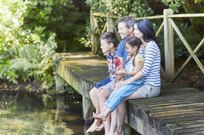 Family sitting at the edge of dock — Stock Photo