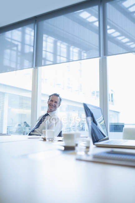 Бизнесмен улыбается в конференц-зале — стоковое фото