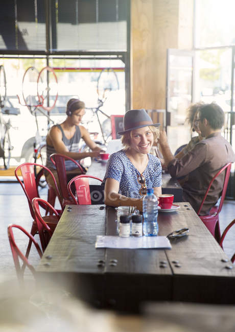 Портрет усміхненої жінки, що п'є каву в кафе — стокове фото