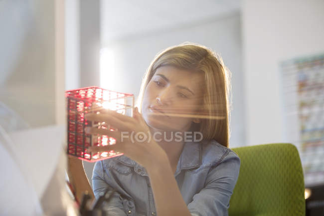 Бізнес-леді вивчає кубик за столом в офісі — стокове фото