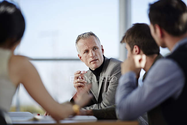 Succès des hommes d'affaires adultes parlant en réunion — Photo de stock