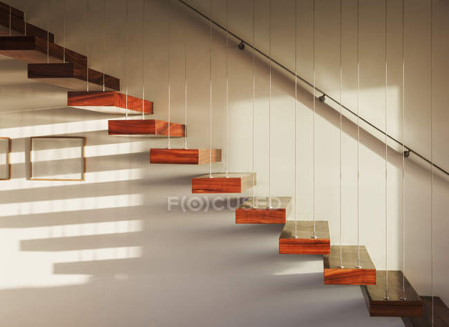 Тени на плавающей лестнице в современном доме — стоковое фото
