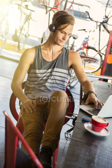 Mann mit Kopfhörer am Laptop in Café — Stockfoto