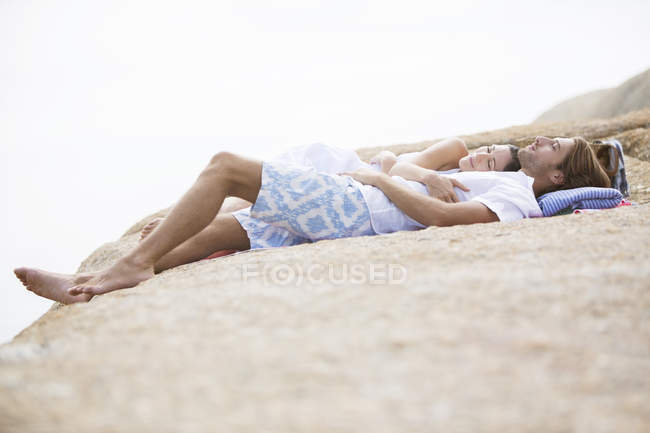 Couple relaxing on rock formation — Stock Photo