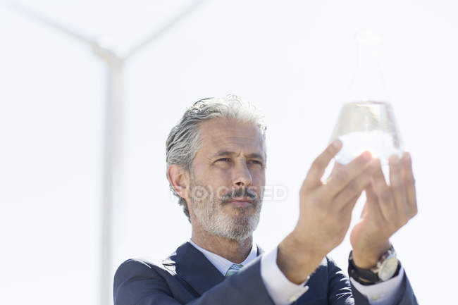 Uomo d'affari che tiene un bicchiere d'acqua all'aperto — Foto stock