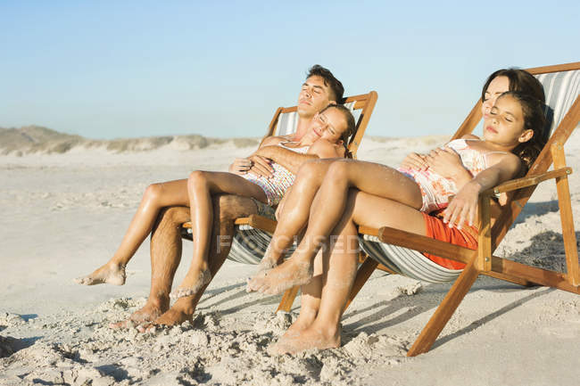Сім'я спить у кріслах для відпочинку на пляжі — стокове фото