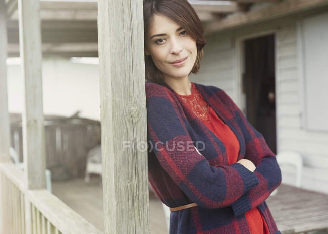 Retrato sorrindo morena mulher no suéter no alpendre — Fotografia de Stock