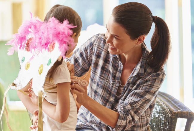 Mother fitting wings on daughter — Stock Photo