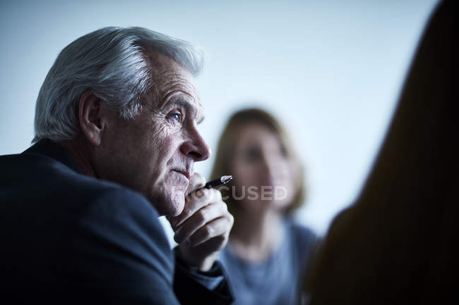 Уважний старший бізнесмен слухає на зустрічі — стокове фото
