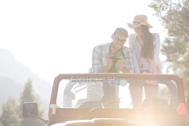 Couple with digital camera in sport utility vehicle — Stock Photo