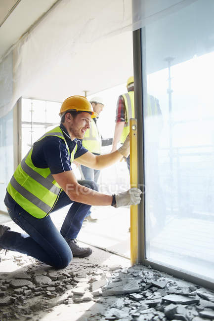 Construction worker using level tool at construction site — Stock Photo