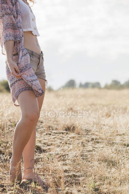 Boho donna in piedi nel soleggiato campo rurale — Foto stock